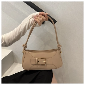 Detail view of the apricot baguette bag showing the buckle and knot shoulder strap