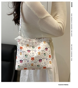Close-up of lace trim and colorful cartoon bear prints on a cream canvas tote bag