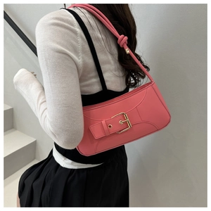 Detailed shot of pink leather underarm bag with gold buckle and knotted strap detail