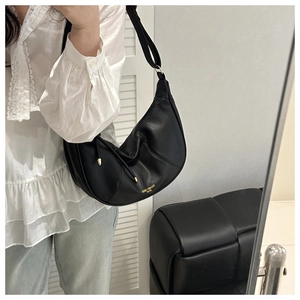 Close-up of black crescent moon bag in pebbled leather with gold hardware detail