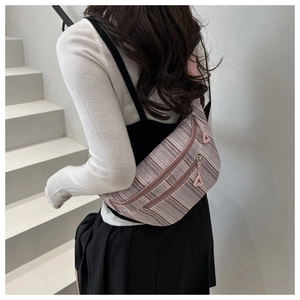 Détail du sac de poitrine en toile rayée rose avec double fermeture éclair et sangle