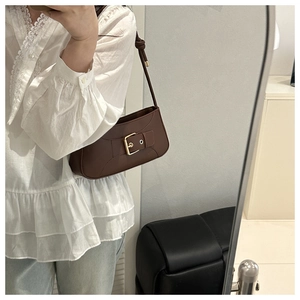 Brown vintage faux leather baguette bag with large metal buckle shown on a model
