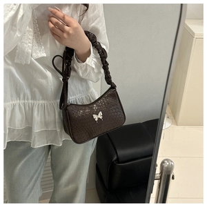 Detail of dark brown faux crocodile shoulder bag featuring silver butterfly buckle