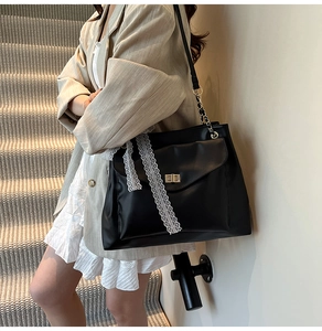 Vue détaillée du cabas en cuir PU noir mat avec rubans de dentelle blanche et fermoir doré