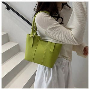 Detailed view of lime green tote bag featuring decorative stitching and metal hardware