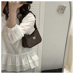Detail of dark brown faux crocodile baguette bag with a silver butterfly metal buckle
