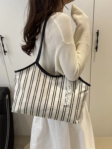 Spacious black and white striped canvas tote bag with leather straps and lace charm detail
