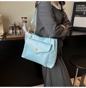 Détail du grand sac cabas bleu clair en similicuir avec fermoir doré et nœud en dentelle