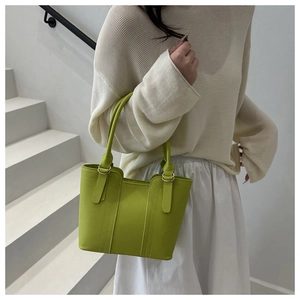 Detail of mint green tote bag with vertical stitching and golden metallic hardware