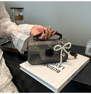 Vue détaillée du mini sac carré vintage gris avec fermoir noir et breloque en perles