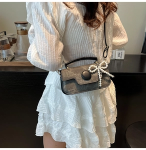 Détail du mini sac bandoulière gris foncé avec charm nœud en perles blanches