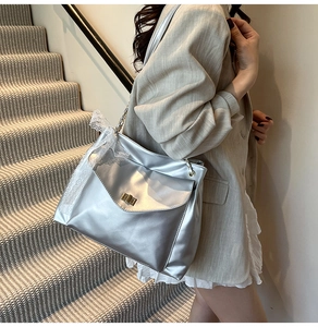 Détail du sac argenté métallisé avec nœud en dentelle blanche et bandoulière chaîne