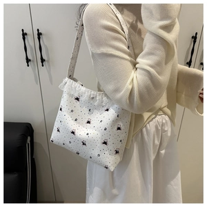 Close-up of white canvas tote with cute bear print and delicate lace trim detail