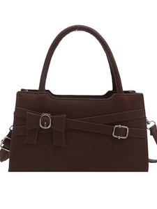 Elegant dark brown leather crossbody bag with a bow detail and silver hardware on white background