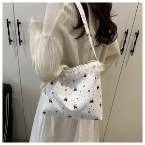 Détail du sac en toile blanche avec imprimé ours mignon et bordure en dentelle