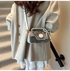 Détail du mini sac en denim et similicuir avec nœud en perles porté par un mannequin