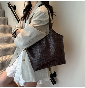 Détails de la texture effet crocodile marron foncé du grand sac cabas porté à l'épaule
