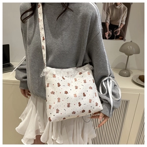 Détail du sac cabas en toile à imprimé ours avec bordure en dentelle blanche et sangle