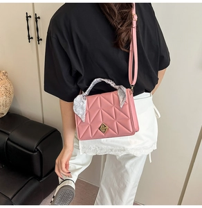 Pink quilted shoulder bag with gold metal lock and silk scarf detail on handle
