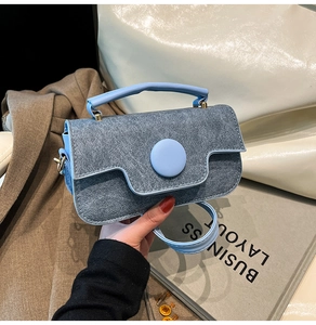 Vue détaillée du mini sac à bandoulière en denim bleu avec boucle ronde et détails perles