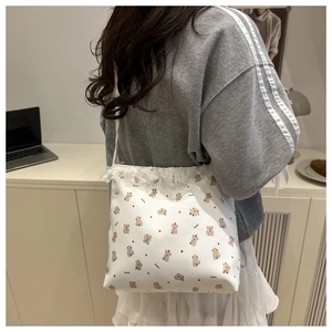 Détail du sac cabas blanc avec imprimé ours et bordure en dentelle délicate