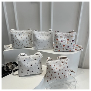 Collection of five white lace canvas tote bags with cute bear prints on tiered display