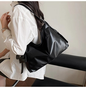 Detail der schwarzen Hobo-Tasche mit verstellbarem Gurt und kleiner seitlicher Zusatztasche