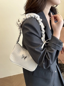 White pleated ruched underarm bag with woven texture and silver butterfly detail
