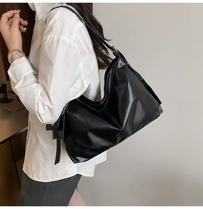 Detail of soft black PU leather hobo tote bag featuring side pocket and shoulder strap