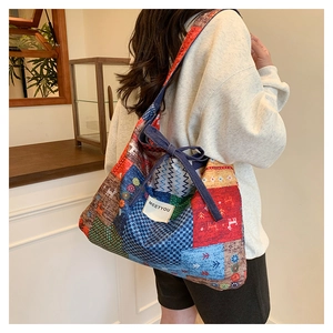 Detailed view of ethnic patchwork canvas crossbody bag with colorful patterns and denim fabrics