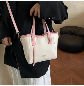 Borsa a mano bicolore in pelle con manici rosa presentata indossata da una modella