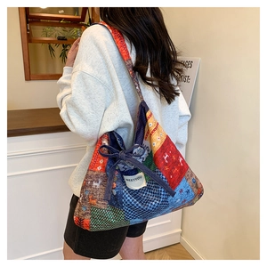 Side view of a large patchwork tote bag with colorful ethnic patterns on canvas fabric