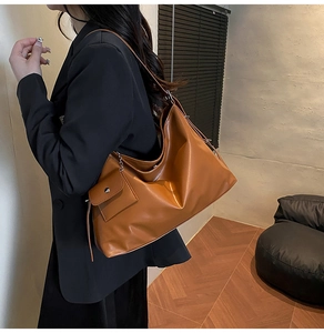 Minimalist caramel brown leather hobo bag with matching small side pouch shown on model