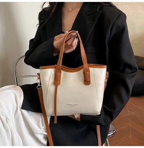 Detail of a contrast color bucket bag showing leather texture and adjustable strap