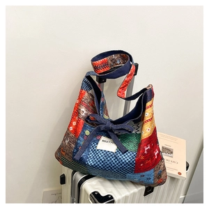 Detail of multi-pattern patchwork tote bag featuring a denim bow and MEETYO fabric label