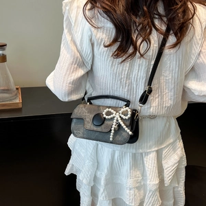 Mini sac bandoulière gris texturé avec grand détail de nœud en perles porté à l'épaule