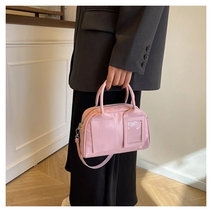Detail of pink glossy Boston bag with transparent card slot and detachable shoulder strap