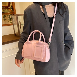Detail of pink Boston bag showing delicate faux leather texture and silver hardware