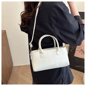 Detail of off-white crossbody bag with fashion print and elegant dual top handles