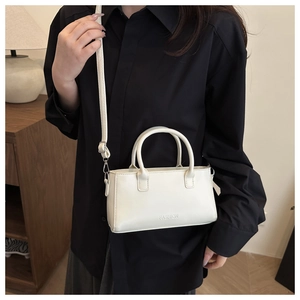 Cream white leather handbag with FASHION engraving and adjustable shoulder strap detail