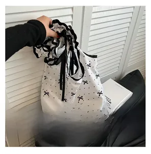 Detail of floral canvas tote bag featuring black bow prints and elegant ruffled edges