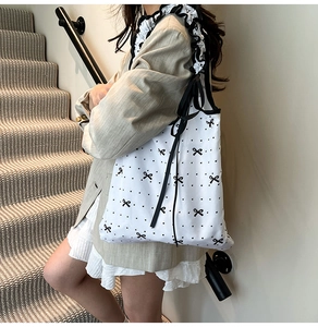 Detail of floral ruffle canvas tote bag with black polka dots and delicate bow prints