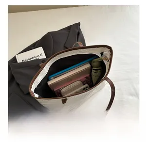 Interior capacity detail of a white woven tote bag holding a tablet and daily essentials