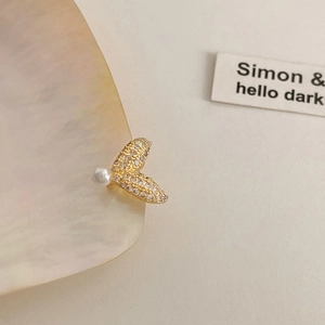 Elegant gold fishtail ear cuff with sparkling zircon crystals and a small white pearl