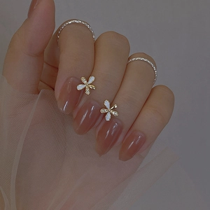 Minimalist white flower stud earrings with gold base and small central gemstone