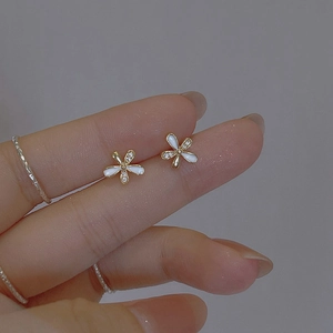 Minimalist gold flower earrings with white enamel petals and small zircon accents