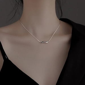Collier argenté moderne avec pendentif géométrique torsadé porté par un mannequin
