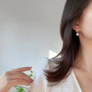 Élégantes boucles d'oreilles dorées ondulées avec diamants et perles blanches