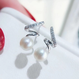 Gros plan de boucles d'oreilles spirales en perles avec accents de zircon brillant
