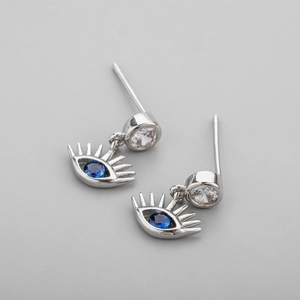 Détail macro de boucles d'oreilles Œil de Turquie en argent avec zircon et pierre bleue